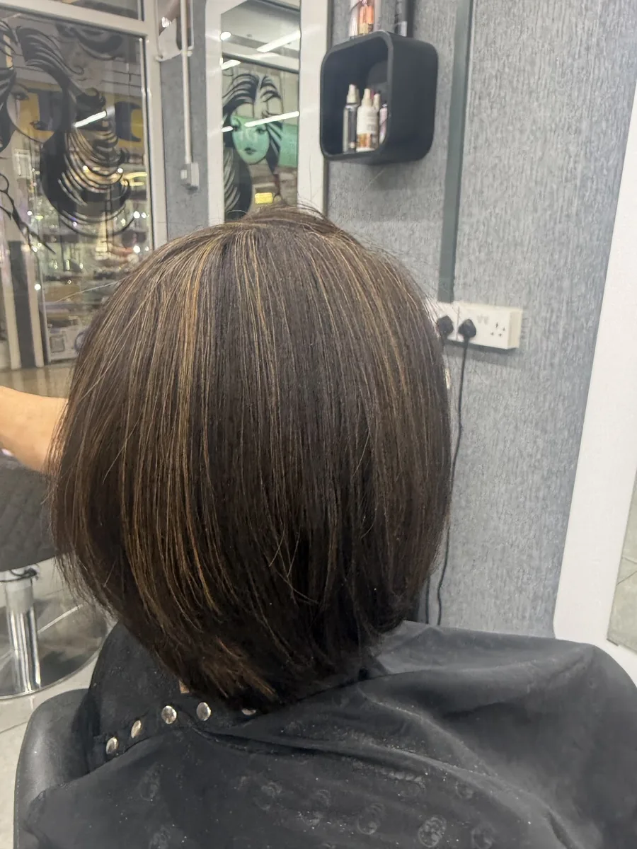 Chin-length brown bob after a cut and blow-dry, seen from further back in the salon